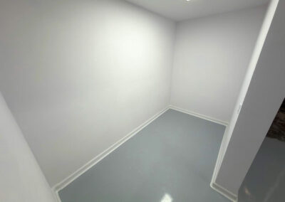 Acabados de grado alimenticio con molduras sanitarias blancas en habitación de envasado hermética