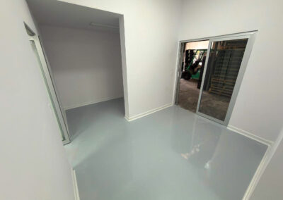 Área de proceso con puerta de cristal y zoclos sanitarios Aislamart que previenen la acumulación de bacterias