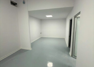 Acabados de grado alimenticio con molduras sanitarias blancas en habitación de envasado hermética